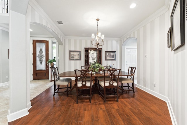 15410 Stable Star Cir, Cypress, TX 77429 - dining room with arched walkways, crown molding, a chandelier, wood finished floors, and wallpapered walls