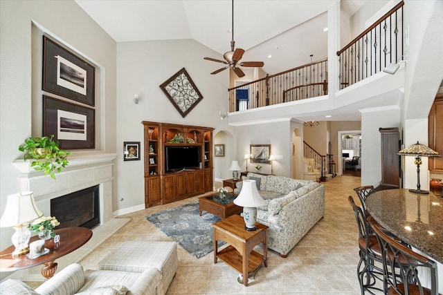 15410 Stable Star Cir, Cypress, TX 77429 - living room with stairway, a ceiling fan, a glass covered fireplace, high vaulted ceiling, and arched walkways