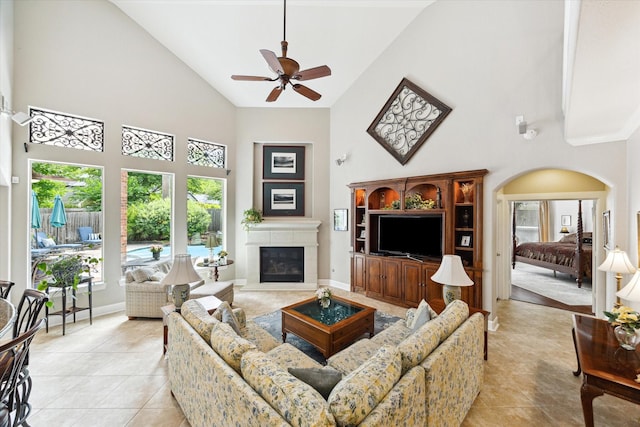 15410 Stable Star Cir, Cypress, TX 77429 - living room with high vaulted ceiling, light tile patterned flooring, ceiling fan, and a glass covered fireplace