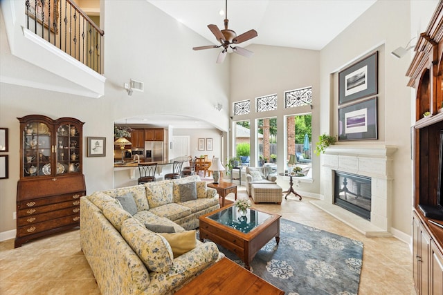 15410 Stable Star Cir, Cypress, TX 77429 - living area with arched walkways, a ceiling fan, high vaulted ceiling, a tile fireplace, and light tile patterned floors