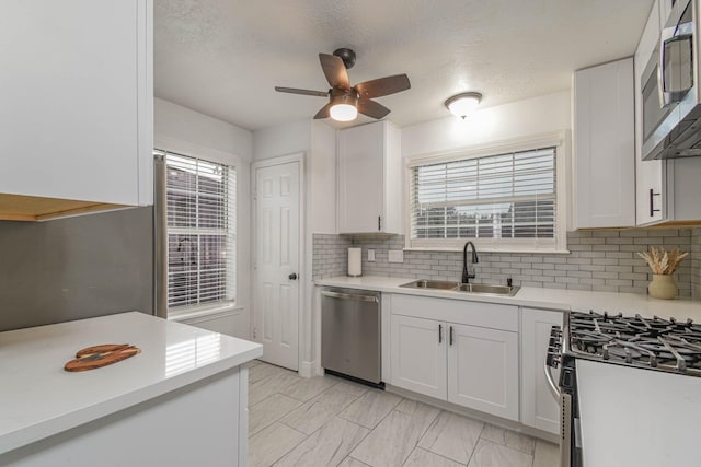 3805 Youpon Dr, La Porte, TX 77571 - kitchen featuring appliances with stainless steel finishes, light countertops, ceiling fan, backsplash, and a textured ceiling