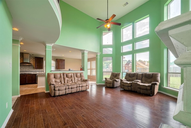 4311 Walden Terrace Ln, Humble, TX 77396 - living area with ornate columns, ceiling fan, dark wood-type flooring, plenty of natural light, and a high ceiling
