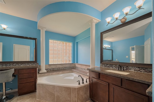 4311 Walden Terrace Ln, Humble, TX 77396 - bathroom with ornate columns, a bath, backsplash, and vanity