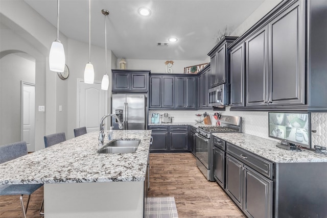 6423 Hunters Creek Ln, Baytown, TX 77521 - kitchen with appliances with stainless steel finishes, arched walkways, a kitchen bar, light stone countertops, and decorative backsplash