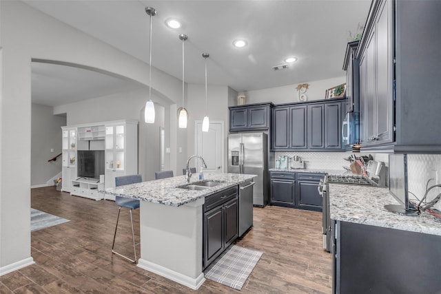 6423 Hunters Creek Ln, Baytown, TX 77521 - kitchen with stainless steel appliances, arched walkways, decorative backsplash, wood finished floors, and light stone countertops
