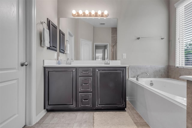 6423 Hunters Creek Ln, Baytown, TX 77521 - bathroom featuring a bath, double vanity, and tile patterned flooring