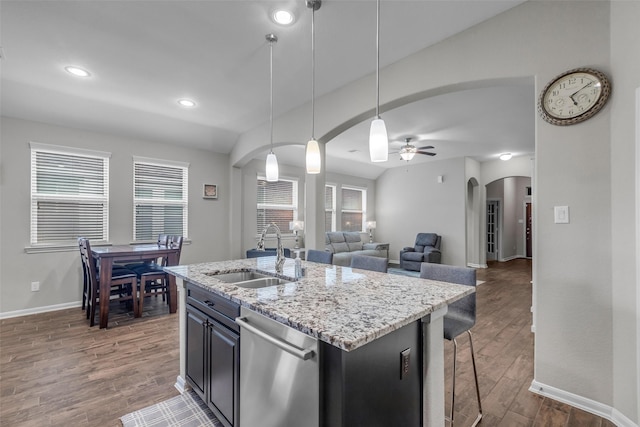 6423 Hunters Creek Ln, Baytown, TX 77521 - kitchen with stainless steel dishwasher, arched walkways, wood finished floors, ceiling fan, and a center island with sink
