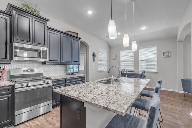 6423 Hunters Creek Ln, Baytown, TX 77521 - kitchen with stainless steel appliances, arched walkways, light stone countertops, decorative backsplash, and recessed lighting