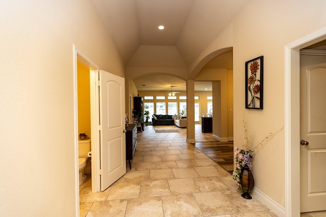 4015 Teramo Ln, Katy, TX 77493 - hallway featuring arched walkways, light stone finish flooring, vaulted ceiling, and recessed lighting