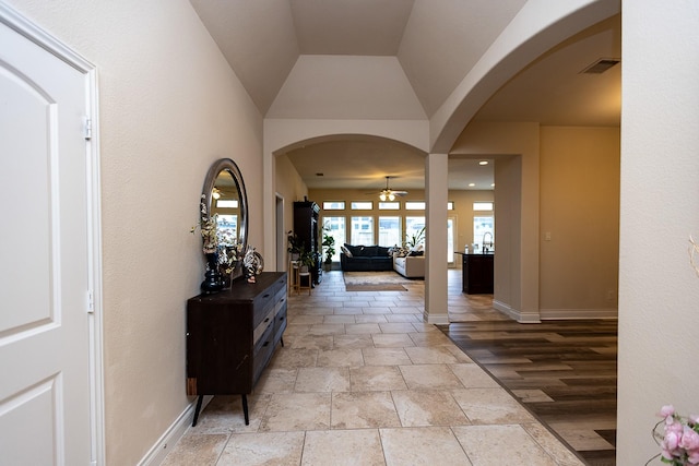 4015 Teramo Ln, Katy, TX 77493 - hall with stone tile floors, arched walkways, and lofted ceiling