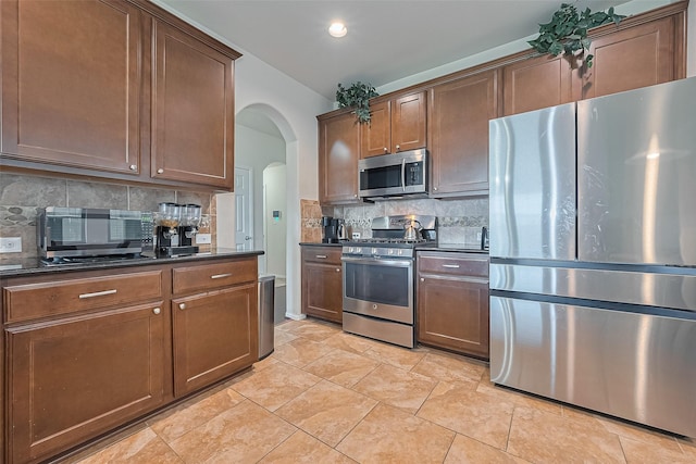 20718 Bandrock Ter, Richmond, TX 77407 - kitchen featuring stainless steel appliances, arched walkways, and backsplash