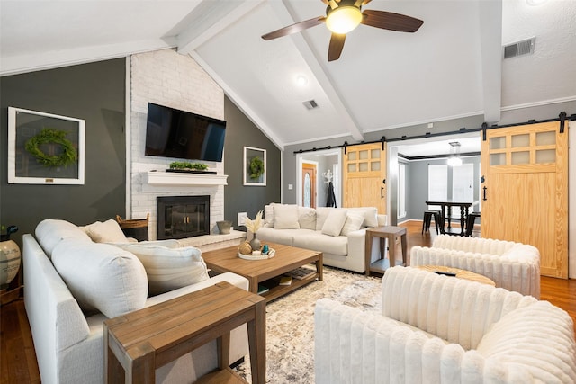 6702 Seinfeld Ct, Houston, TX 77069 - living room with a barn door, wood finished floors, a ceiling fan, and a fireplace