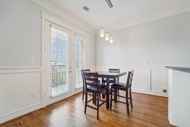 2802 Morrison St Unit 203, Houston, TX 77009 - dining space with a decorative wall, ornamental molding, wainscoting, and wood finished floors