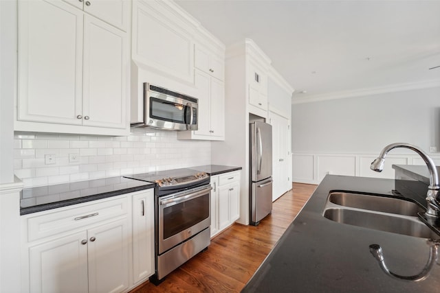 2802 Morrison St Unit 203, Houston, TX 77009 - kitchen featuring appliances with stainless steel finishes, dark countertops, crown molding, white cabinets, and dark wood-style flooring