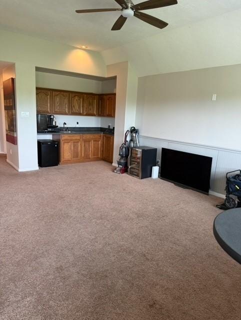 2547 Crystal Shore Dr, Rosharon, TX 77583 - kitchen featuring open floor plan, light colored carpet, lofted ceiling, brown cabinets, and dark countertops
