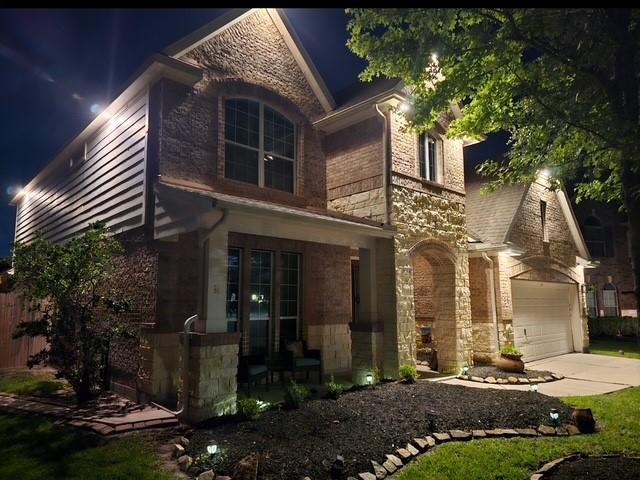 2547 Crystal Shore Dr, Rosharon, TX 77583 - view of front facade featuring stone siding, an attached garage, and concrete driveway