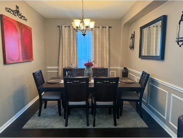 2547 Crystal Shore Dr, Rosharon, TX 77583 - dining room featuring a chandelier, wainscoting, wood finished floors, and a decorative wall
