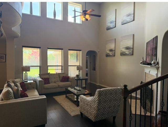 2547 Crystal Shore Dr, Rosharon, TX 77583 - living room featuring a ceiling fan, healthy amount of natural light, a towering ceiling, dark wood finished floors, and arched walkways