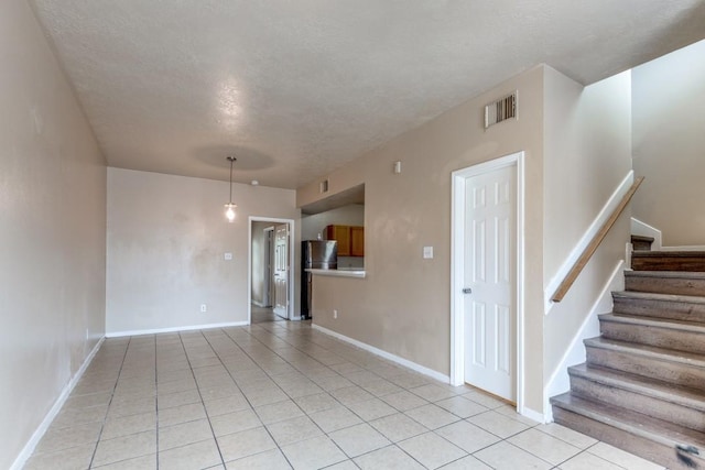 8126 Jutland Rd, Houston, TX 77033 - unfurnished room with a textured ceiling, light tile patterned floors, and stairway