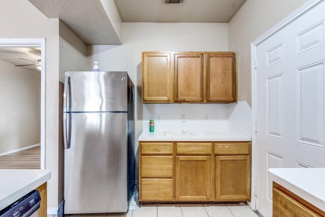 8126 Jutland Rd, Houston, TX 77033 - kitchen featuring freestanding refrigerator, dishwasher, ceiling fan, light countertops, and brown cabinets