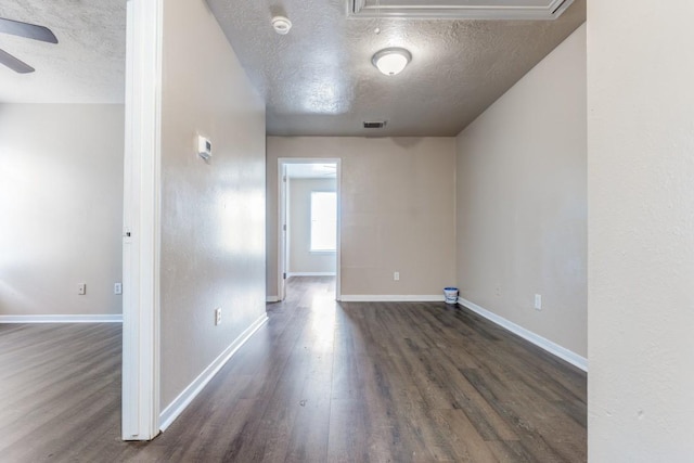 8126 Jutland Rd, Houston, TX 77033 - empty room featuring a textured ceiling, attic access, dark wood-type flooring, ceiling fan, and a smoke detector