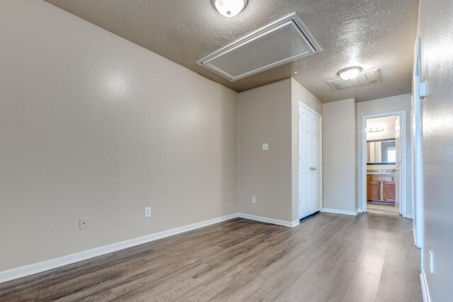 8126 Jutland Rd, Houston, TX 77033 - empty room with attic access, wood finished floors, and a textured ceiling