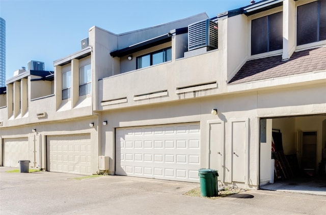 1112 Bering Dr Unit 47, Houston, TX 77057 - rear view of house featuring a garage, stucco siding, and driveway