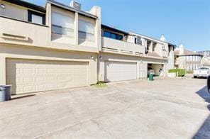 1112 Bering Dr Unit 47, Houston, TX 77057 - rear view of house featuring an attached garage, a balcony, driveway, and stucco siding