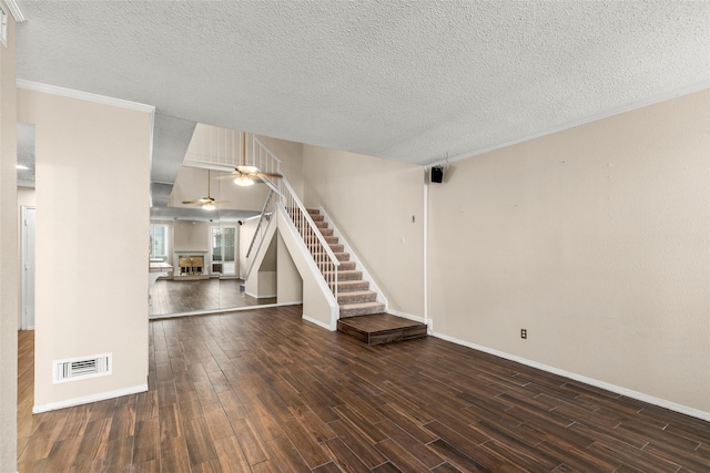 1112 Bering Dr Unit 47, Houston, TX 77057 - unfurnished living room featuring ceiling fan, dark wood-style floors, a textured ceiling, stairway, and crown molding