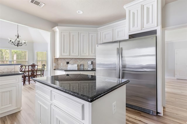 1018 N Commons View Dr, Houston, TX 77336 - kitchen featuring stainless steel fridge, tasteful backsplash, light wood finished floors, a chandelier, and white cabinetry
