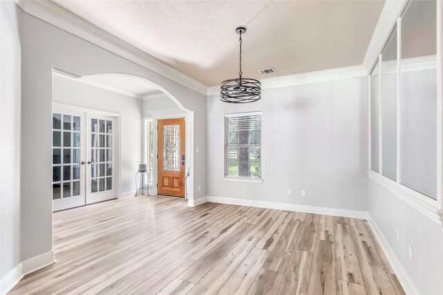 1018 N Commons View Dr, Houston, TX 77336 - unfurnished dining area featuring french doors, a chandelier, light wood finished floors, crown molding, and arched walkways