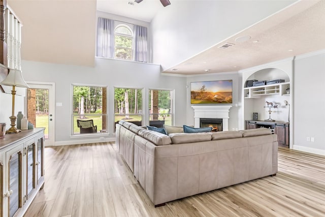 1018 N Commons View Dr, Houston, TX 77336 - living area with a lit fireplace, light wood-type flooring, a high ceiling, a ceiling fan, and recessed lighting