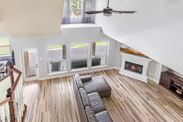 1018 N Commons View Dr, Houston, TX 77336 - living room featuring wood finished floors, a ceiling fan, a glass covered fireplace, and vaulted ceiling