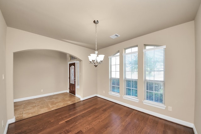 9119 Basin Ridge Ln, Richmond, TX 77407 - empty room featuring arched walkways, a chandelier, and wood finished floors