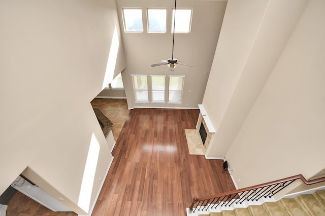 9119 Basin Ridge Ln, Richmond, TX 77407 - foyer entrance featuring a high ceiling, stairway, wood finished floors, a ceiling fan, and a fireplace