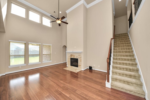 9119 Basin Ridge Ln, Richmond, TX 77407 - unfurnished living room with a ceiling fan, a fireplace, stairs, plenty of natural light, and a towering ceiling