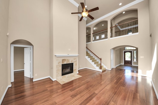 9119 Basin Ridge Ln, Richmond, TX 77407 - unfurnished living room featuring a high ceiling, a ceiling fan, a tile fireplace, wood finished floors, and recessed lighting