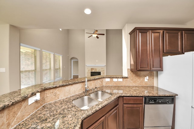 9119 Basin Ridge Ln, Richmond, TX 77407 - kitchen featuring dishwasher, decorative backsplash, a ceiling fan, light stone countertops, and a glass covered fireplace