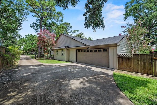 5617 Valerie St, Houston, TX 77081 - view of home's exterior featuring an attached garage, driveway, roof with shingles, and brick siding
