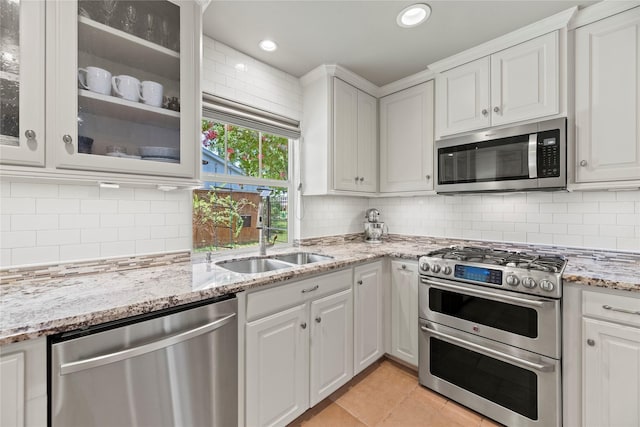 5617 Valerie St, Houston, TX 77081 - kitchen with appliances with stainless steel finishes, white cabinetry, light tile patterned floors, tasteful backsplash, and recessed lighting
