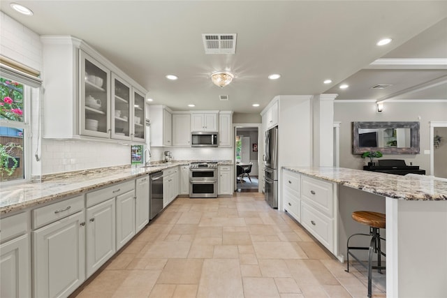5617 Valerie St, Houston, TX 77081 - kitchen featuring stainless steel appliances, white cabinetry, tasteful backsplash, and recessed lighting