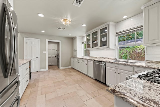 5617 Valerie St, Houston, TX 77081 - kitchen featuring stainless steel appliances, tasteful backsplash, white cabinets, glass insert cabinets, and recessed lighting