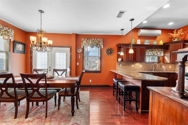 1820 Winnie St, Galveston, TX 77550 - dining room featuring an AC wall unit, dark wood-style floors, recessed lighting, and a chandelier