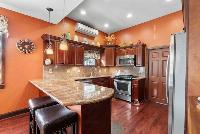1820 Winnie St, Galveston, TX 77550 - kitchen featuring stainless steel appliances, a wall mounted AC, a peninsula, dark wood-style floors, and backsplash