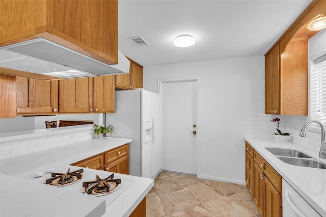16622 Ben Nevis Dr, Houston, TX 77084 - kitchen with white appliances, light countertops, brown cabinets, and tasteful backsplash