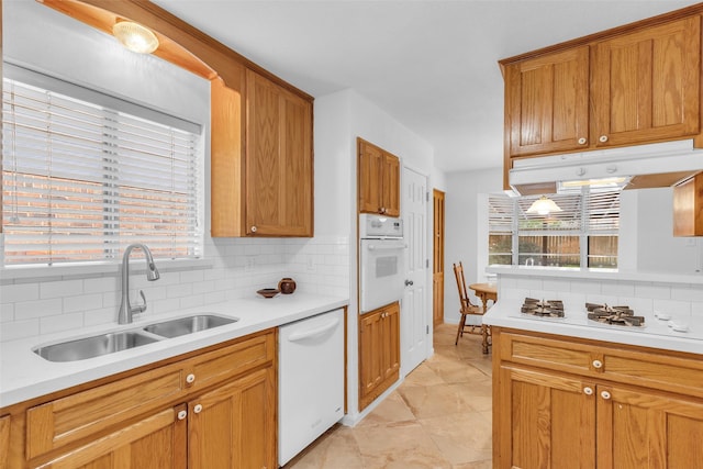 16622 Ben Nevis Dr, Houston, TX 77084 - kitchen with white appliances, under cabinet range hood, backsplash, and light countertops