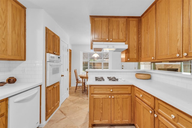 16622 Ben Nevis Dr, Houston, TX 77084 - kitchen with white appliances, under cabinet range hood, tasteful backsplash, and light countertops
