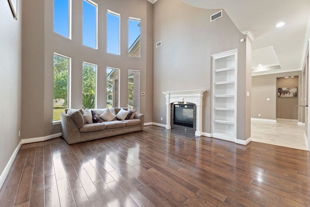 13506 Key Ridge Ln, Cypress, TX 77429 - living area featuring wood-type flooring, a premium fireplace, built in shelves, a towering ceiling, and recessed lighting