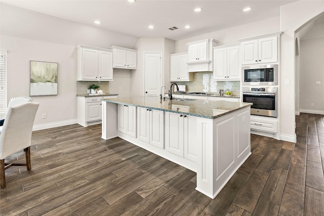 19002 Dublin Bay Blvd, Tomball, TX 77377 - kitchen featuring appliances with stainless steel finishes, white cabinets, decorative backsplash, dark wood finished floors, and recessed lighting