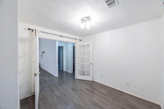 8526 Greenleaf Lake Dr, Houston, TX 77095 - empty room with dark wood-type flooring, a textured ceiling, and french doors